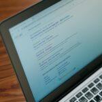 Laptop mit Google-Suchergebnissen auf Holztisch, zeigt Suchergebnisse zu Babysitten und Kinderbetreuung