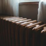Alter Gusseisen-Heizkörper mit Entlüftungsventil oben, benötigt Wartung und Entlüftung für optimale Heizleistung