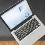 Laptop zeigt Analytics-Dashboard mit Diagrammen und blauen Datenvisualisierungen für SEO-Analyse und Website-Optimierung