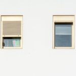 Fenster mit Holzrahmen, linkes Fenster mit geklemmt wirkendem Rolladen, rechtes Fenster mit offener Fassade