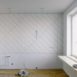 Renovierungsraum mit Gipskartonwand im Rautenmuster, Elektroinstallationen und Leitungen während der Sanierung