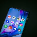 Smartphone mit Social-Media-Apps auf dem Displayscreen zeigt YouTube, Facebook, Instagram, WhatsApp und weitere Plattformen für Handwerker-Marketing
